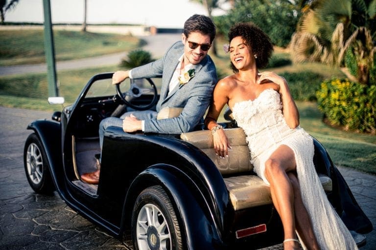 wedding couple lounging on small car
