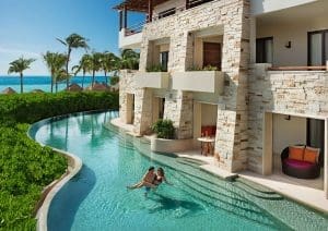 couple enjoying their swimup room at secrets akumal